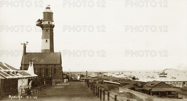 Karachi Harbour at Manora Island. Manora Point lighthouse and St. Paul's Church sit on the edge of Manora Island overlooking Karachi Harbour. Manora Island, India (Pakistan), circa 1910. Manora Island, Sindh, Pakistan, Southern Asia, Asia.