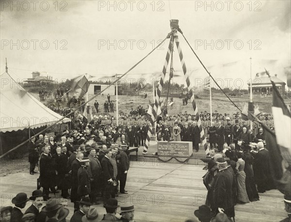 Laying the Parliament foundation stone, Perth. A crowd gathers to watch Sir Arthur and Lady Annie Lawley lay the foundation stone of the Parliament of Western Australia at St. George's Terrace. The couple stand behind the inscribed block, posing for the camera beside Premier Walter James (right of Lady Lawley), and Captain Wolfe Murray (left behind Sir Lawley). Perth, Australia, July 1902. Perth, West Australia, Australia, Australia, Oceania.