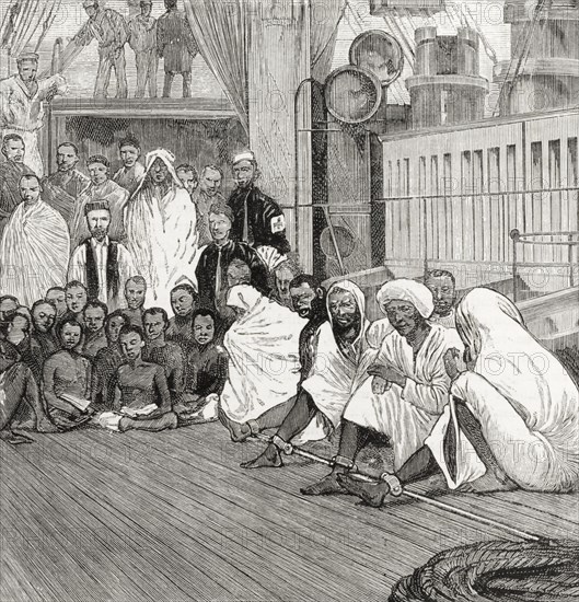 Slave traders captured by the British Royal Navy. An illustration taken from the front page of 'The Graphic' newspaper depicts a group of Arab slave traders shackled together on the deck of HMS Garnet following their capture from an illegal slave dhow by the British Royal Navy. Liberated slaves and interpreters sit behind them. Indian Ocean, 20 October 1888., Indian Ocean, Africa.