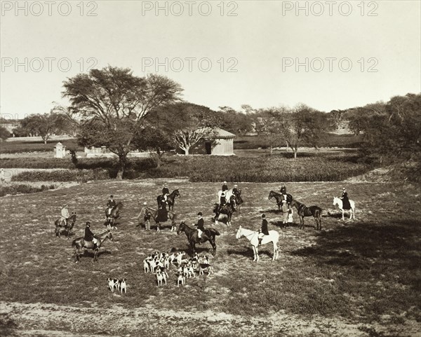 A meet of horses and hounds at Sialkot. A British hunting party gathers for a meet at the start of a English-style hunt in Sialkot. Mounted on horseback, the group comprises men and women, dressed in full riding gear and accompanied by a pack of hunting hounds. Sialkot, Punjab, India (Punjab, Pakistan), 1882. Sialkot, Punjab, Pakistan, Southern Asia, Asia.