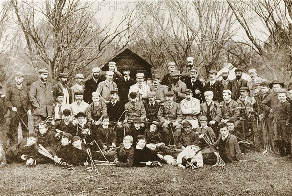 New Zealand golfers. A photograph printed in 'The Sketch' newspaper features a group of male golfers, posing for an outdoor portrait with their golf clubs. Adult men stand at the back whilst boys wearing caps sit in the front row. Probably Christchurch, New Zealand, 1895. Christchurch, Canterbury, New Zealand, New Zealand, Oceania.