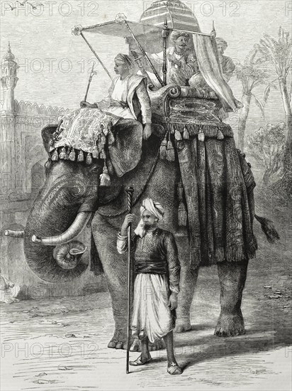 An Indian nobleman rides a decorated elephant. An illustration from the 'The British Workman' depicts an Indian nobleman seated in an ornate howdah on the back of a decorated elephant. The elephant is directed by its mahout (elephant handler) who sits on its shoulders, 'ankusha' in hand. India, circa 1875. India, Southern Asia, Asia.