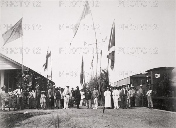 A new Nigeria Railways station at Ibadan. Opening ceremony for a new Nigeria Railways station at Ibadan. A crowd of European and African people gather on the platform beneath an array of flags. Ibadan, Oyo State, Nigeria, 5 March 1901. Ibadan, Oyo, Nigeria, Western Africa, Africa.