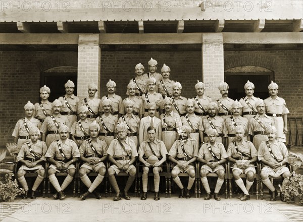 Jhelum Police, 1938. Uniformed ranking officers of the Jhelum Police pose for a group portrait to commemorate the departure of the Superintendent of Police, Ray Mellor. Jhelum, Punjab, India (Pakistan), 28 September 1938. Jhelum, Punjab, Pakistan, Southern Asia, Asia.