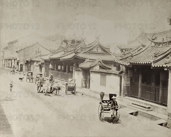 Thian Hock Keng Temple. View of Thian Hock Keng Temple, located in Telok Ayer Street. 'Jinrikishas' or rickshaws, bullock carts and pedestrians pass in the street. One rickshaw appears to have a licence plate, dating the photograph to after the 1888 licensing provisions for rickshaws. Singapore, Straits Settlements (Singapore), 1901. Singapore, Central (Singapore), Singapore, South East Asia, Asia.