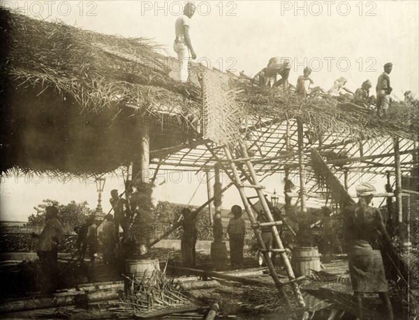 Thatching a roof for the royal visit. A team of Ceylonian men thatch the roof of a spectator stand in preparation for a visit from the Duke and Duchess of Cornwall and York (later King George V and Queen Mary). The royal couple stopped in Ceylon (Sri Lanka) on their way to open the first Commonwealth Parliament of Australia in Melbourne. Colombo, Ceylon (Sri Lanka), April 1901. Colombo, West (Sri Lanka), Sri Lanka, Southern Asia, Asia.