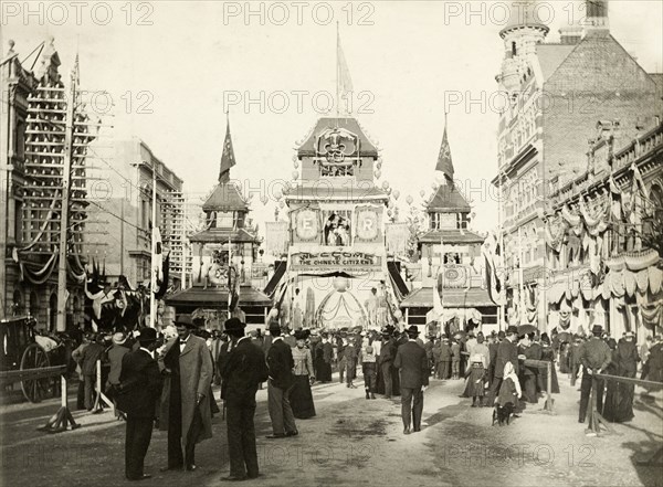 Awaiting the royal welcome procession, Perth. Crowds mill about on the street in front of a decorative arch in Perth's China Town district, as they await a welcome procession for the Duke and Duchess of Cornwall and York (later King George V and Queen Mary). Perth, Australia, July 1901. Perth, West Australia, Australia, Australia, Oceania.