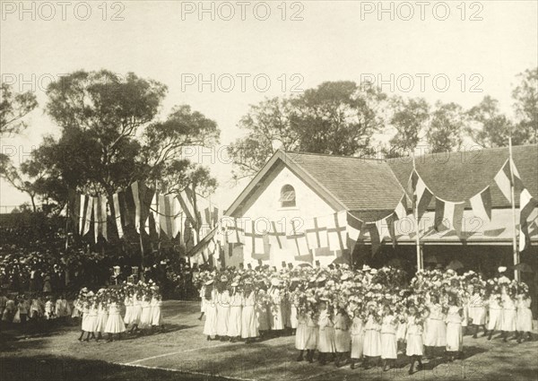 Schoolgirls perform a floral dance for the royal visit. Schoolgirls dressed in white uniforms perform a dance with flowers for the Duke and Duchess of Cornwall and York (later King George V and Queen Mary) on their visit to Perth. Perth, Australia, 25 July 1901. Perth, West Australia, Australia, Australia, Oceania.