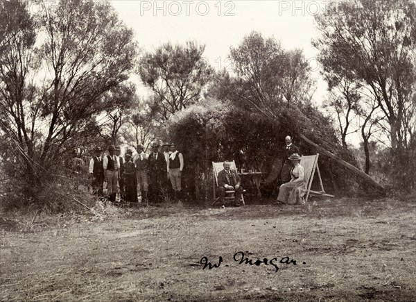 The Lawleys share a drink with Alfred Morgans. Sir Arthur Lawley, Governor of Western Australia, and his wife, Annie, enjoy drinks with Alfred Morgans (left), Premier of Western Australia in the autumn of 1901. The team of men standing behind them are probably labourers at a Mount Morgan gold mine. Mount Morgan, Australia, 1901. Mount Morgan, Queensland, Australia, Australia, Oceania.