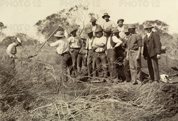 The Lawleys at Laverton gold fields. Sir Arthur Lawley, Governor of Western Australia, shovels earth onto a gold shaker operated by his wife, Lady Annie Lawley, whilst a team of miners look on. The machine was designed to sift through dirt and gravel, carrying the heavier gold to the bottom. Laverton, Australia, circa 1901. Laverton, West Australia, Australia, Australia, Oceania.