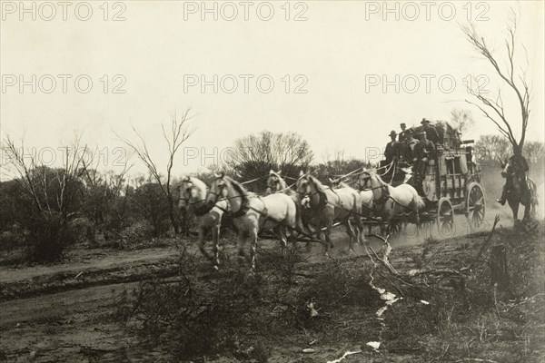 Stage coach travel in the outback. Six horses pull a stage coach full of people along a dirt track in the outback. The coaches were used to transport travellers from one town to another before the arrival of the railroad. Western Australia, Australia, circa 1901., West Australia, Australia, Australia, Oceania.