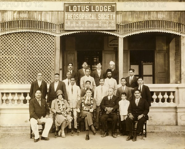 The Theosophical Society in Mandalay. A group of suited Burmese men assemble for a photograph with a European couple outside 'Lotus Lodge', the headquarters of the Theosophical Society in Mandalay. Mandalay, Burma (Myanmar), circa 1930. Mandalay, Mandalay, Burma (Myanmar), South East Asia, Asia.