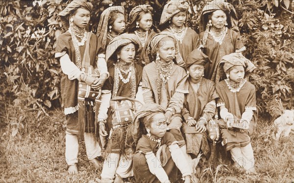 Young Shan women in traditional dress. Posed portrait of a group of young Shan women. Traditionally dressed, they wear 'longyis', tassled head scarves and jewellery including necklaces and earrings. Burma (Myanmar), circa 1926., Shan, Burma (Myanmar), South East Asia, Asia.