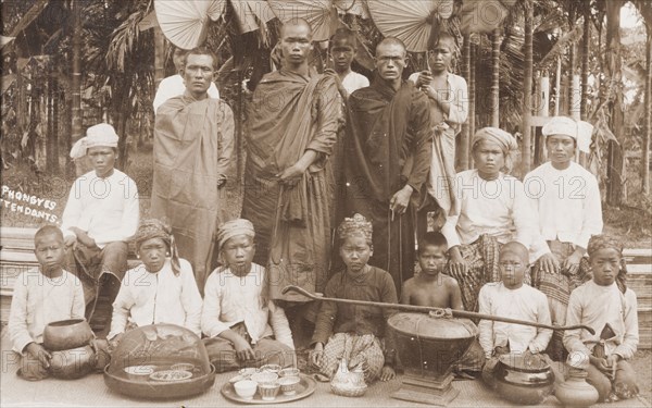 Burmese 'phongyes' with their young attendants. Three robed 'phongyes' (priests) pose for the camera with their young male attendants. The boys sit behind a variety of bowls and dishes, which were used to beg for food each morning from local houses. Burma (Myanmar), circa 1926. Burma (Myanmar), South East Asia, Asia.
