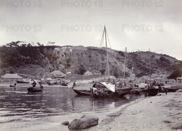 Sampans at anchor in Shau Kei Wan bay. Several small sampans sit at anchor on the sandy shore of Shau Kei Wan bay. Shau Kei Wan, Hong Kong, China, circa 1903. Shau Kei Wan, Hong Kong, China, People's Republic of, Eastern Asia, Asia.