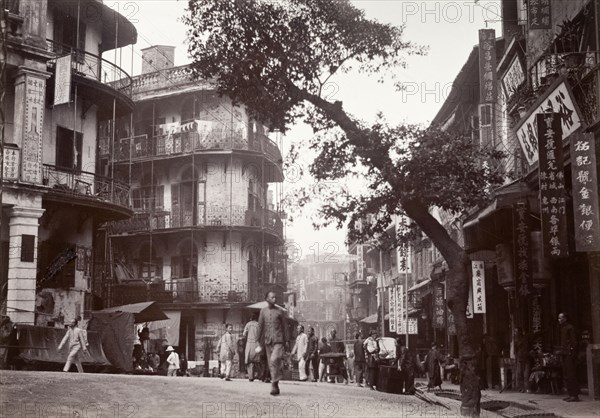 Junction of Queen's Road and Jervois Street, Hong Kong. Street traders sell their wares to passers-by at the junction of Queen's Road and Jervois Street. Multi-storey buildings flank the road, covered with vertical signs that advertise goods and services in Chinese script. Hong Kong, China, circa 1903. Hong Kong, Hong Kong, China, People's Republic of, Eastern Asia, Asia.