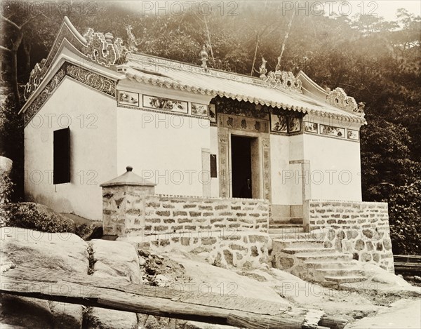 Joss house in Shau Kei Wan. Exterior view of a small Joss house (Chinese temple) in Shau Kei Wan. Illustrated panels decorate the eaves beneath the building's ornate roof. Shau Kei Wan, Hong Kong, China, circa 1905. Shau Kei Wan, Hong Kong, China, People's Republic of, Eastern Asia, Asia.