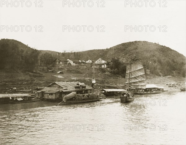 A 'likin' station on the Xijiang River. A 'likin' (Chinese provincial tax) station on the banks of the Xijiang River is protected by guard boats. Likin was levied at many inland stations upon imports or articles in transit. Probably Canton Province (Guangdong), China, circa 1906., Guangdong, China, People's Republic of, Eastern Asia, Asia.