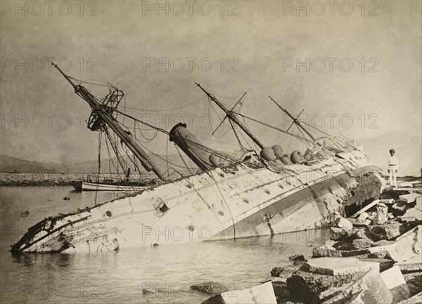 HMS Phoenix capsized by a typhoon. HMS Phoenix, a British naval steamship, lies upturned in shallow waters after she was capsized by a devastating typhoon that killed an estimated 10,000 people. Kowloon, Hong Kong, China, circa 19 September 1906. Kowloon, Hong Kong, China, People's Republic of, Eastern Asia, Asia.