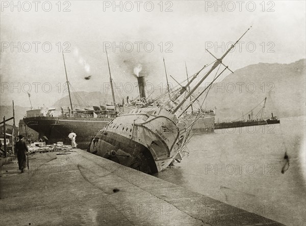 British naval ships stricken by a typhoon. Two British naval steamships, HMS Phoenix and RMS Monteagle, lie stricken in shallow waters in the aftermath a devastating typhoon that killed an estimated 10,000 people. Kowloon, Hong Kong, China, circa 19 September 1906. Kowloon, Hong Kong, China, People's Republic of, Eastern Asia, Asia.