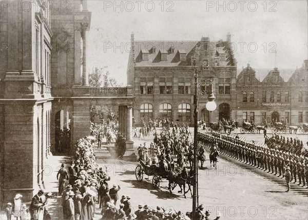 Sir Arthur Lawley leaves the Ou Raadsaal, Pretoria. British soldiers line the street outside the Ou Raadsaal (Old Council Chamber) in Pretoria, as Sir Arthur Lawley (1860-1932), Lieutenant Governor of the Transvaal, departs in a horse-drawn carriage after the opening of the Legislative Council of the Transvaal. Pretoria, South Africa, 20 May 1903. Pretoria, Gauteng, South Africa, Southern Africa, Africa.