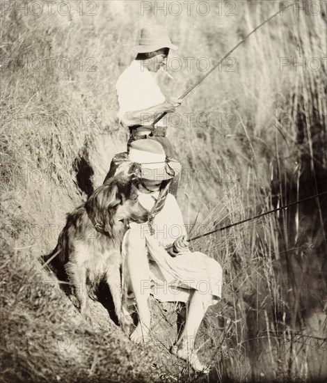 Cecilia Lawley fishing in South Africa. Informal portrait of Cecilia Lawley, the youngest daughter of Sir Arthur Lawley, Lieutenant Governor of the Transvaal. Accompanied by Colonel Holdsworth and her pet dog Gholi, she is pictured fishing, wearing a wide-brimmed hat that covers most of her face. South Africa, circa 1903. South Africa, Southern Africa, Africa.