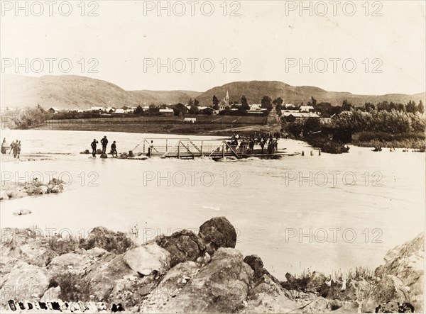 Flooding in Heidelberg. A footbridge is partially submerged in the swollen waters of the Biesbok Spruit River. According to an original caption, the flood was caused by 'an exceptional storm in 1893'. Heidelberg, Eastern Transvaal (Mpumalanga), South Africa, 1893. Heidelberg, Mpumalanga, South Africa, Southern Africa, Africa.
