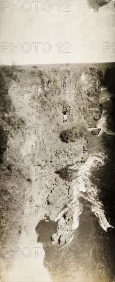 Chair lift over Victoria Falls. A lone passenger crosses the Zambezi gorge in a chair lift attached to a cable system high above the river at Victoria Falls. Matabeleland, Rhodesia (Matabeleland North, Zimbabwe), circa 1904., Matabeleland North, Zimbabwe, Southern Africa, Africa.