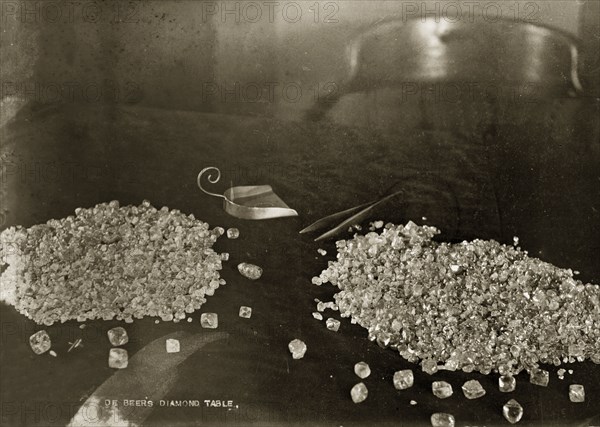 De Beers diamonds. Two piles of diamonds sit on a table at the De Beers offices in Kimberley, with a pair of tweezers and a scoop positioned beside them. Kimberley, South Africa, circa 1896. Kimberley, North Cape, South Africa, Southern Africa, Africa.