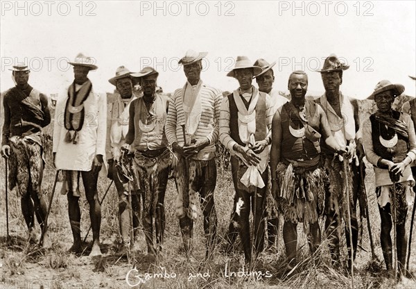 Gambo with Matabele indunas. Portrait of a group of Matabele (Ndebele) indunas (chiefs), including Gambo, a principal negotiator for the Matabele people in peace talks with the British during the Matabele rebellion of 1896. The men wear ceremonial gorgets, given to them by the British, with Western shirts, waistcoats, broad-brimmed hats and traditional animal pelt aprons. Rhodesia (Zimbabwe), circa 1897. Zimbabwe, Southern Africa, Africa.