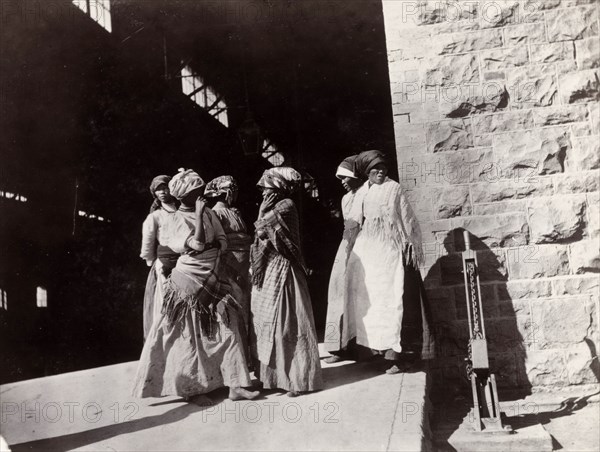 Female workers at the De Beers diamond mine. Six African women, employed as workers for the De Beers diamond mine, stand at the entrance to a factory building. Kimberley, South Africa, circa 1896. Kimberley, North Cape, South Africa, Southern Africa, Africa.