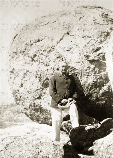 Cecil Rhodes at the Matopos Hills. Cecil Rhodes (1853-1902) stands amongst the granite boulders of the Matopos Hills. At his own request, Rhodes was eventually buried in these hills, at a spectacular site, Malindudzimu, which he christened 'World's View'. Near Bulawayo, Rhodesia (Zimbabwe), circa 1897., Matabeleland North, Zimbabwe, Southern Africa, Africa.