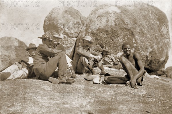 Cecil Rhodes and companions at the Matopos Hills. Cecil Rhodes (third from left) and his companions sit amongst the granite boulders of the Matopos Hills. At his own request, Rhodes was eventually buried in these hills, at a spectacular site, Malindudzimu, which he christened 'World's View'. Near Bulawayo, Rhodesia (Zimbabwe), circa 1897. Bulawayo, Matabeleland North, Zimbabwe, Southern Africa, Africa.
