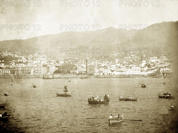 Funchal Bay, Madeira. Rowing boats bob about in Funchal Bay near to the coastal city of Funchal. Funchal, Madeira, circa 1897. Funchal, Madeira, Madeira Islands (Portugal), Atlantic Ocean, Africa.