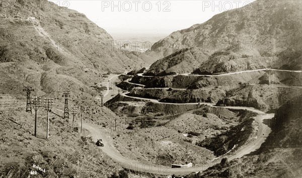 View of the Khyber Pass. A motorcar travels along the winding Khyber Pass, a strategically important route in the Safed Koh Mountains, connecting British India (now Pakistan) with Afghanistan. Landi Khana, North West Frontier Province, India (Pakistan), circa 1924., North West Frontier Province, Pakistan, Southern Asia, Asia.