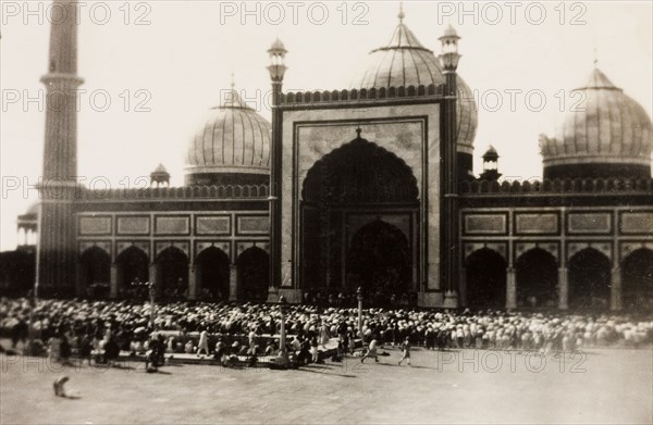 Friday prayers at the Jama Masjid, Delhi. A congregation of Muslim men gather outside Jama Masjid for 'Jumu'ah' (Friday prayer). The mosque was commissioned during the reign of Mughal Emperor Shah Jahan (r.1628-1658), and can accommodate up to 25,000 worshippers in its courtyard. Delhi, India, circa 1928. Delhi, Delhi, India, Southern Asia, Asia.