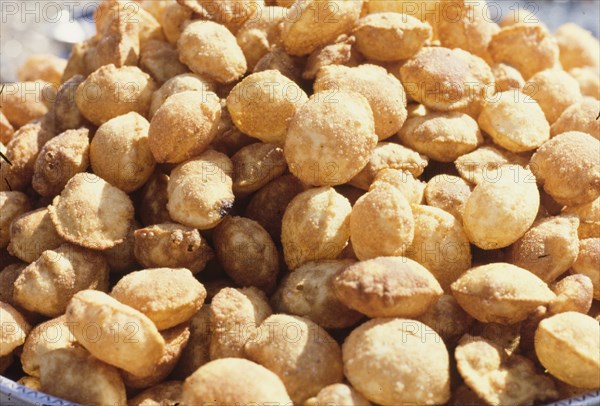 A heap of freshly cooked puris. A heap of freshly cooked puris, on display at an outdoor market. A puri (poori) is a type of Indian unleavened bread, which is made from atta dough and deep-fried, filling the bread with steam and causing it to balloon. India. India, Southern Asia, Asia.