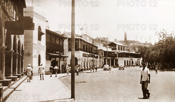 A street in Steamer Point, Aden. A line of buildings with open balconies flanks the main street running through the maritime town of Steamer Point. Steamer Point, Aden, Yemen, 1943. Aden, Adan, Yemen, Middle East, Asia.