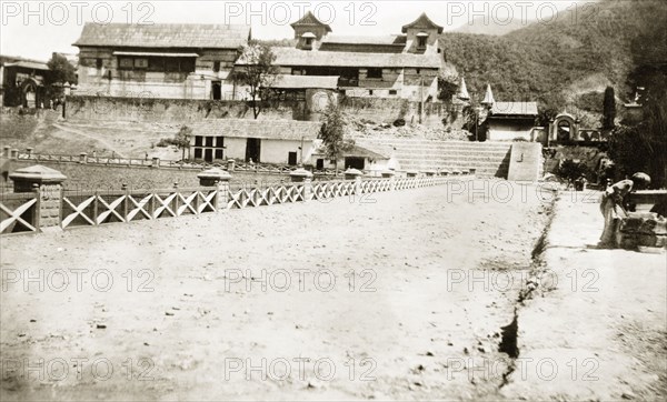 Palatial residence in northern India. View down a driveway, looking towards the rear of a large, palatial residence. An original caption labels this as: 'The Palace, Mandi', but it is unclear whether this locates the building in Mandi, Himachal Pradesh, or perhaps more likely, refers to the Mubarak Mandi Palace, located in Jammu City in the State of Jammu and Kashmir. Northern India, 1920. Mandi, Himachal Pradesh, India, Southern Asia, Asia.
