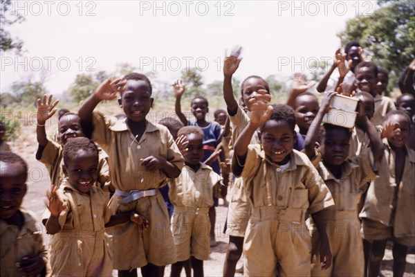 Ghanaian schoolboys wave goodbye. A group of uniformed schoolboys wave goodbye. Pong-Tamale, Ghana, circa 1961. Pong-Tamale, North (Ghana), Ghana, Western Africa, Africa.