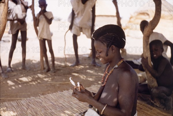 A Fulani woman uses hand spindles. A Fulani woman spins yarn using hand spindles. Kuka, Ghana, circa March 1961. Kuka, Upper East, Ghana, Western Africa, Africa.