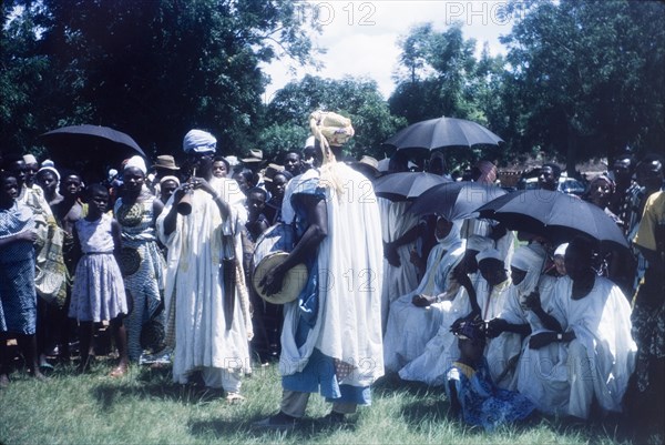 Zongo musicians at a Ngmayem festival. Crowds at an annual Ngmayem harvest festival are entertained by Zongo musicians who play a drum and horn. Odumasi, Ghana, circa 1960. Odumasi, East (Ghana), Ghana, Western Africa, Africa.