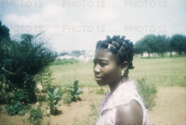 Ghanaian woman with a traditional hairstyle. Profile portrait of a Ghanaian woman wearing a traditional or 'candlewick' hairstyle. Bechem, Ghana, circa 1960. Bechem, Brong Ahafo, Ghana, Western Africa, Africa.