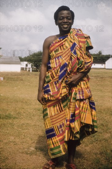 Traditional Ghanaian dress. Portrait of Mr Dako Mamphey wearing traditional Ghanaian kente cloth. Saltpond, Ghana, June 1958. Saltpond, West (Ghana), Ghana, Western Africa, Africa.