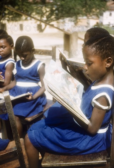 Schoolgirls read books from class library. Several young schoolgirls read books from the class library at Philip Quaque Girls School. Cape Coast, Ghana, March 1958. Cape Coast, Central (Ghana), Ghana, Western Africa, Africa.