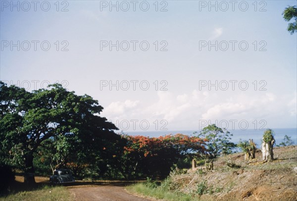 Coastal road in Saltpond. View looking towards the sea of a coastal road in Saltpond. Saltpond, Ghana, circa 1960. Saltpond, West (Ghana), Ghana, Western Africa, Africa.