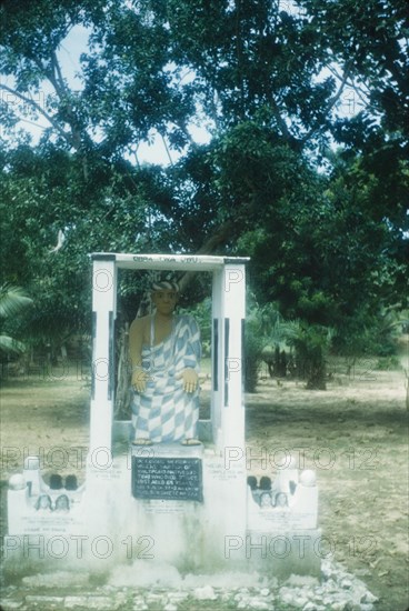 Commemorative monument at Saltpond. A commemorative roadside monument features a painted sculpture of a Saltpond resident who died in 1951. Lowtown, Saltpond, Ghana, 4 July 1960. Saltpond, West (Ghana), Ghana, Western Africa, Africa.