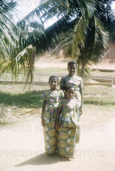 Ghanaian girls in kente cloth. Portrait of three Ghanaian girls dressed in outfits made from traditional kente cloth. Saltpond, Ghana, circa 1957. Saltpond, West (Ghana), Ghana, Western Africa, Africa.