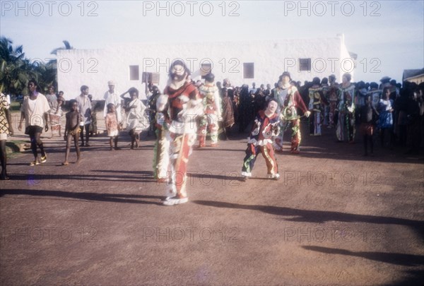 Performing masqueraders. Costumed masqueraders perform at an outdoor ceremony to celebrate Ghana becoming a Republic under the leadership of President Kwame Nkrumah (1909-1972). Saltpond, Ghana, 1 July 1960. Saltpond, West (Ghana), Ghana, Western Africa, Africa.