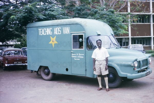 Mr Soah with a Teaching Aids Van. A smiling Government employee, Mr Soah, poses by a Teaching Aids Van outside the Ministry of Education. Accra, Ghana, circa 1960. Accra, East (Ghana), Ghana, Western Africa, Africa.